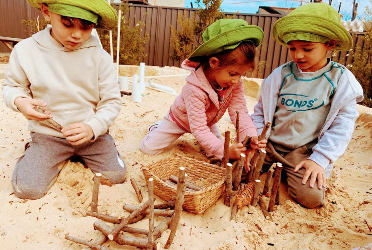 Preschoolers at Grace Village Early Learning play and build in the sand during outdoor play